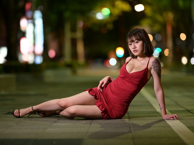 Азиатка в коротком красном платье с татуировками на теле