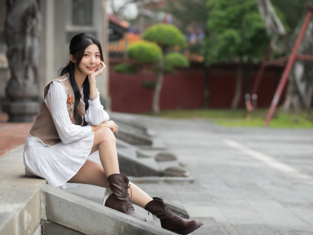 Азиатка сидит на холодных ступеньках