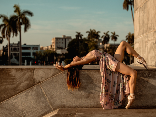 Девушка балерина в платье греется на солнце