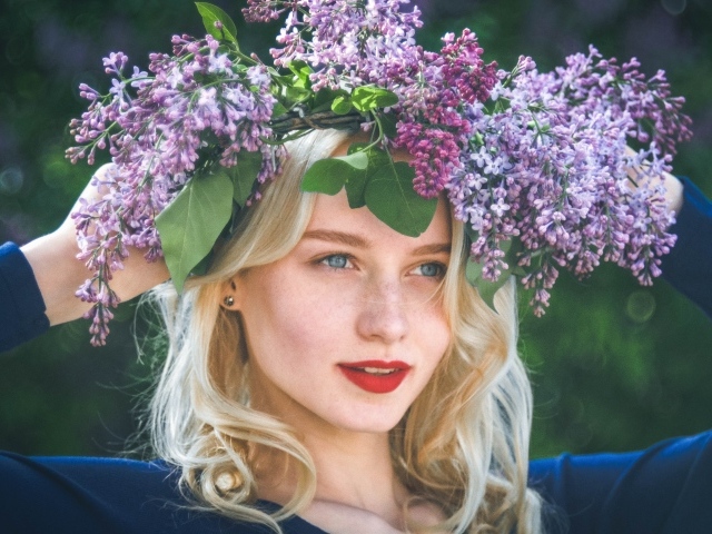 Красивая голубоглазая девушка с венком из сирени на голове