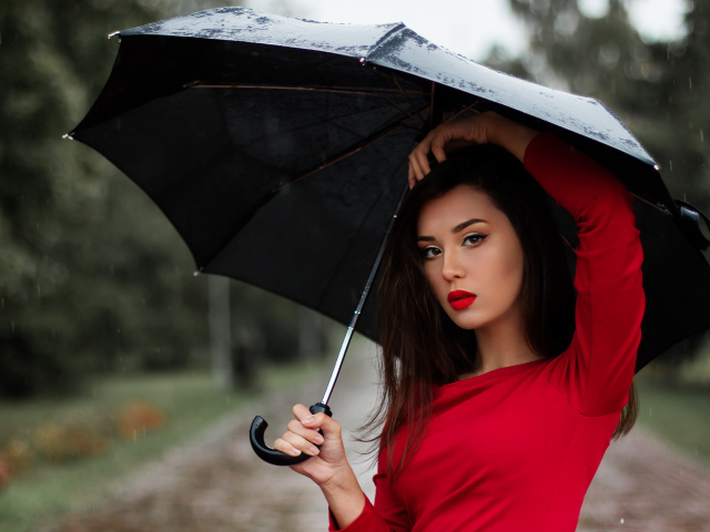 Красивая девушка в красном платье под черным зонтом