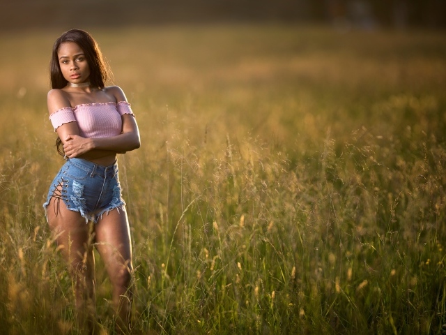 Красивая девушка стоит на поле в траве