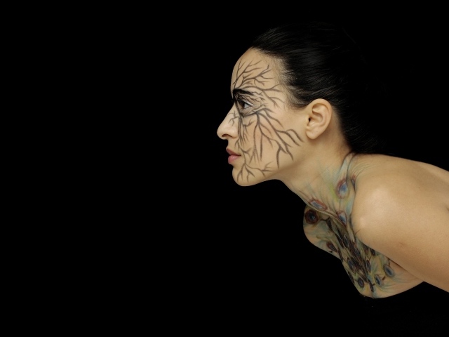 Красивая девушка с рисунком на теле на черном фоне