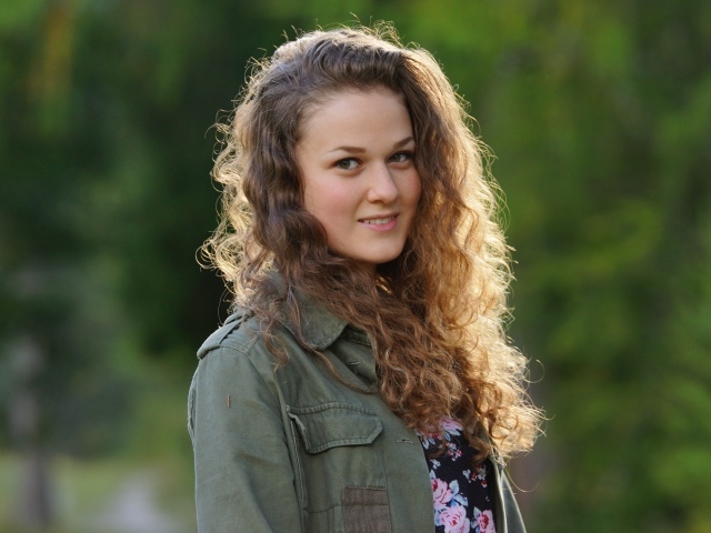 Красивая девушка с кудрявыми волосами в лучах солнца