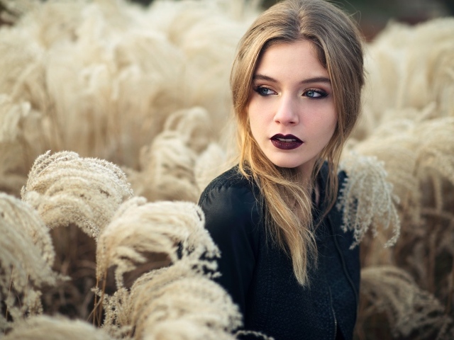 Красивая девушка с макияжем на лице позирует на природе