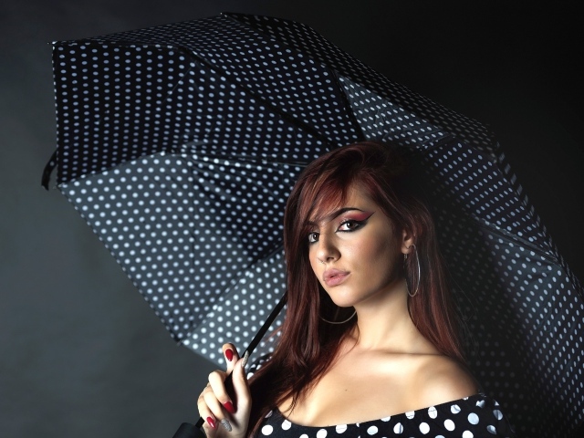 Яркая девушка под зонтом на сером фоне