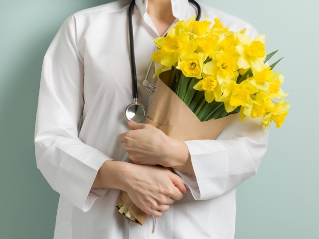 Доктор в букетом нарциссов  в руках