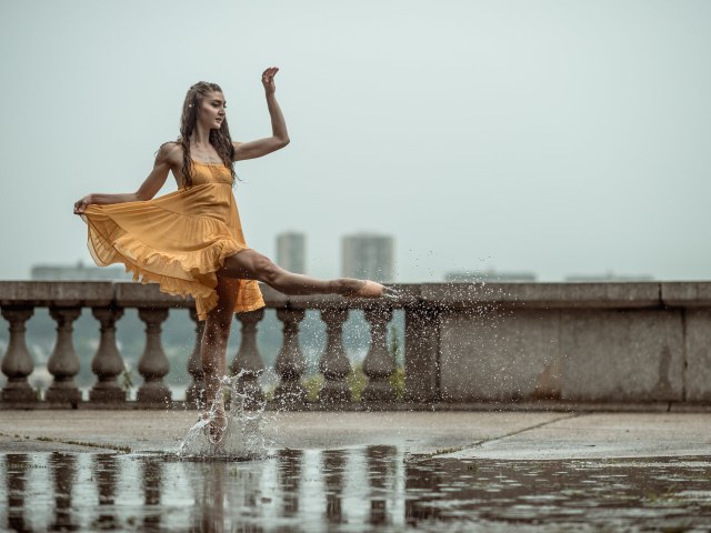 Девушка балерина идет по луже