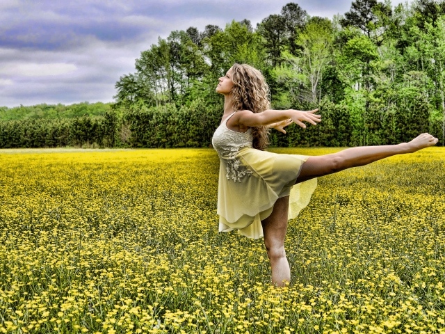 Девушка танцует на поле с желтыми цветами