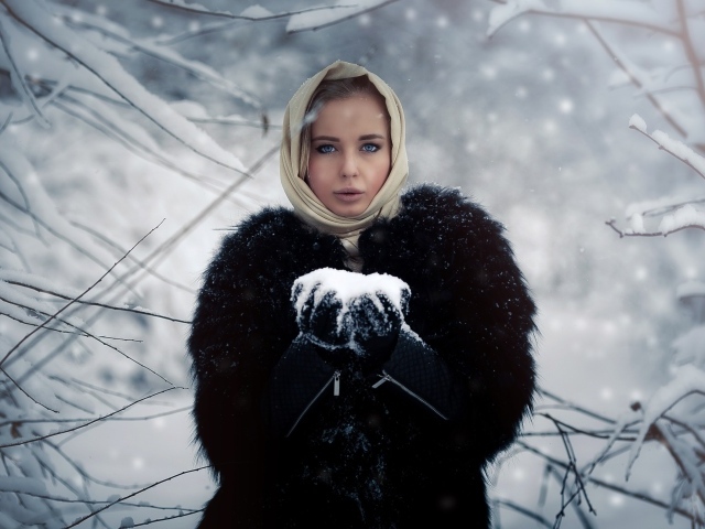 Девушка в черной шубе в заснеженном лесу