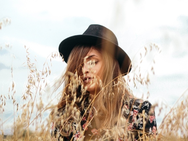 Девушка в черной шляпе в траве