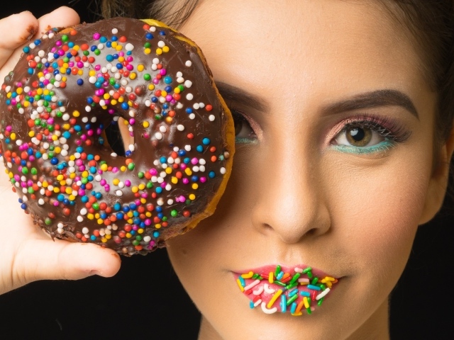 Девушка с пончиком в шоколаде в руках