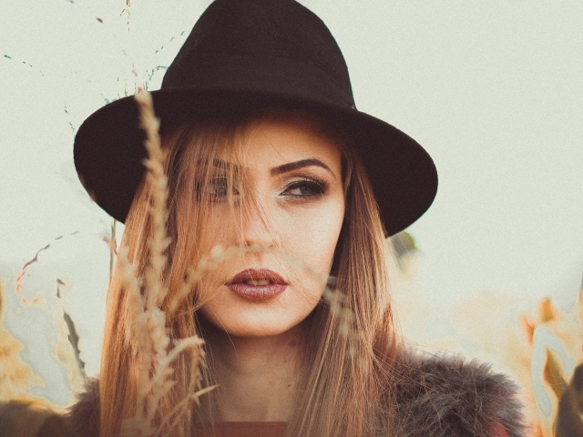 Серьезная девушка в черной шляпе 