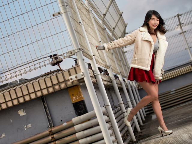 Улыбающаяся девушка азиатка в теплой куртке