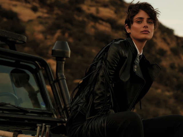 Модель Тейлор Хилл в черной куртке сидит на машине