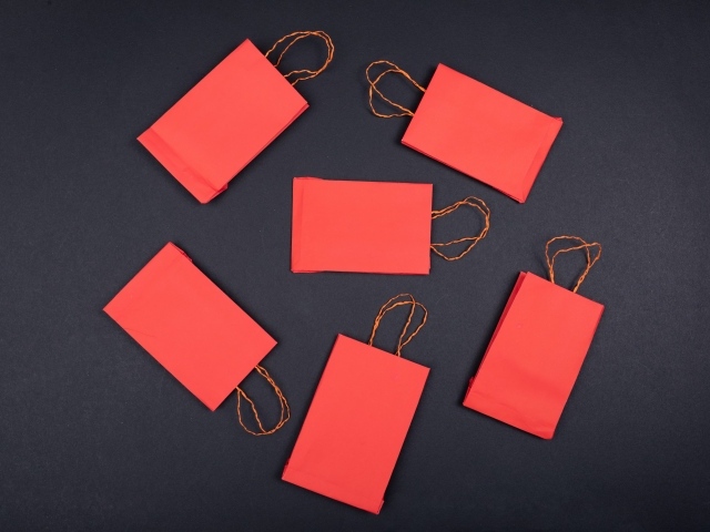 Красные пакетики для подарков на черном столе