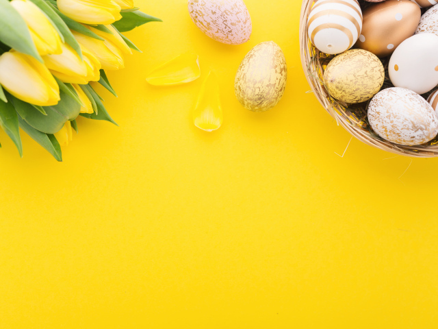 Букет тюльпанов и разноцветные яйца на желтом фоне на Пасху