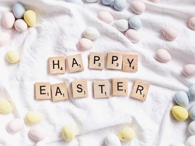 Текст  Счастливой Пасхи и пасхальные яйца на покрывале