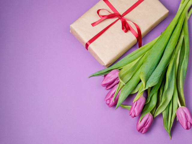 Подарок и букет красивых тюльпанов на сиреневом фоне