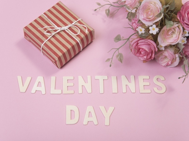 Цветы и подарок на розовом фоне на День Святого Валентина