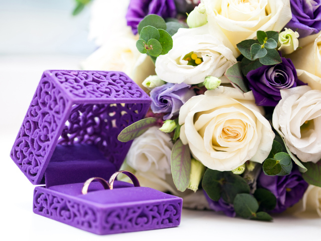 Красивая коробочка с кольцами и букетом цветов на столе