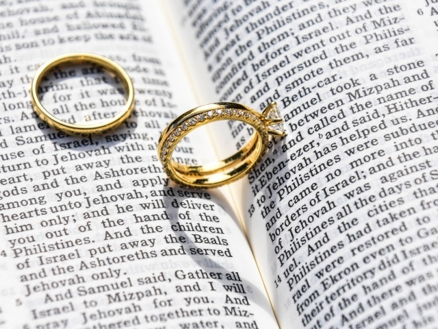 Два золотых обручальных кольца лежат на газете