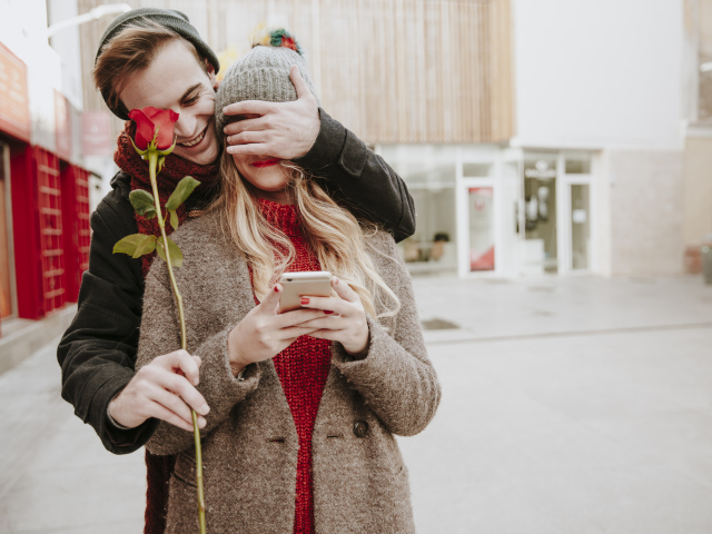 Влюбленный парень дарит девушке красную розу