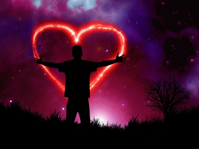 Мужчина рисует красное сердце в ночном небе