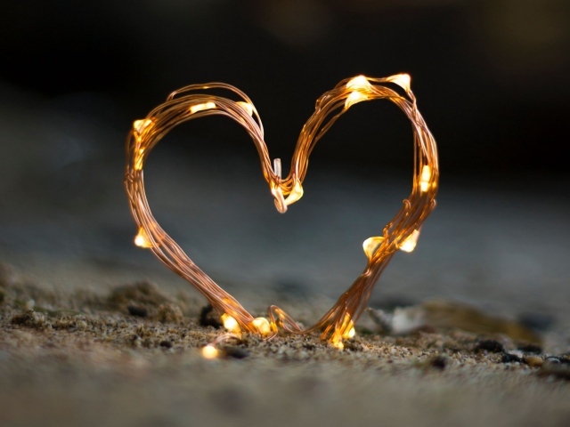 Сердце из гирлянды на песке
