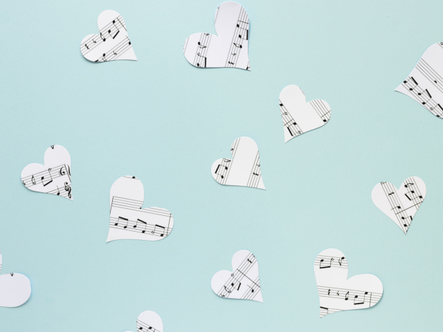 Сердечки из нотной тетради на голубом фоне