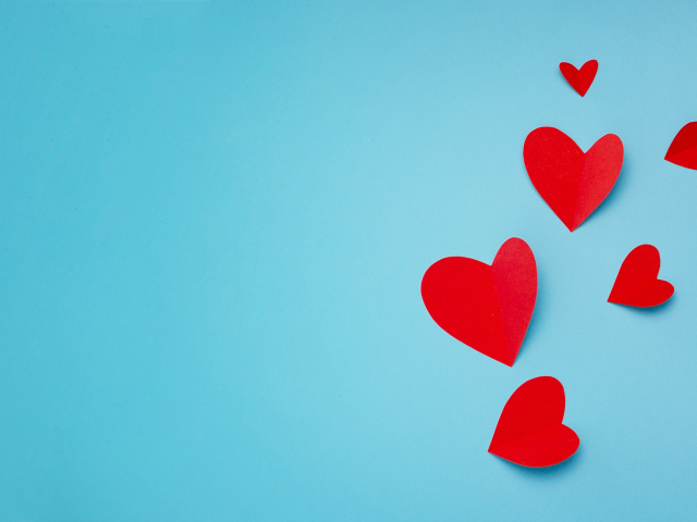 Много красных бумажных сердечек на голубом фоне