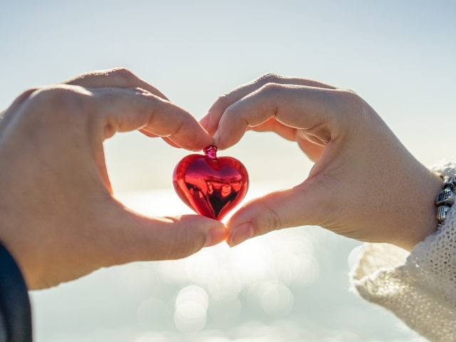 Маленькое сердечко в руках влюбленной пары