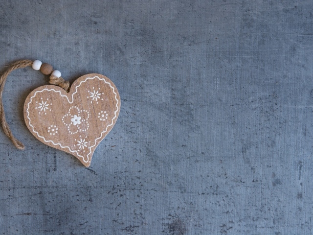 Деревянное сердце на нитке на сером фоне