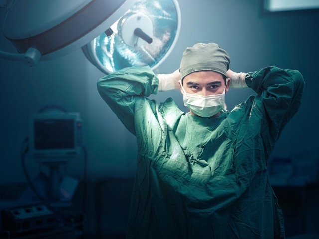 Мужчина врач в костюме в операционной