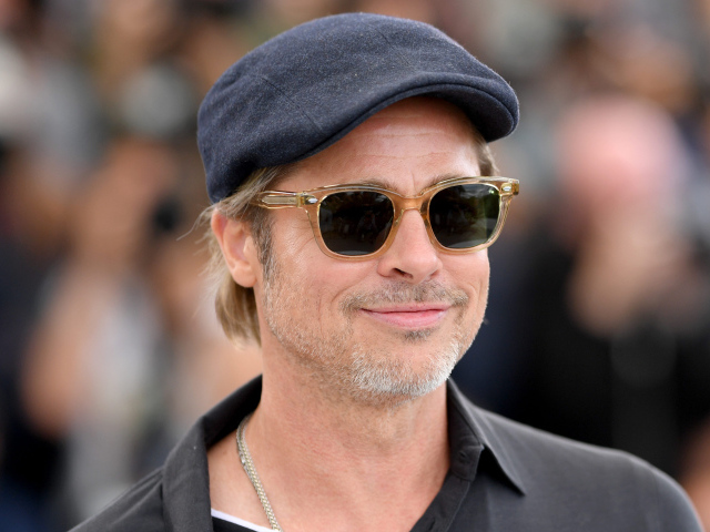 Актер Брэд Питт в кепке и очках