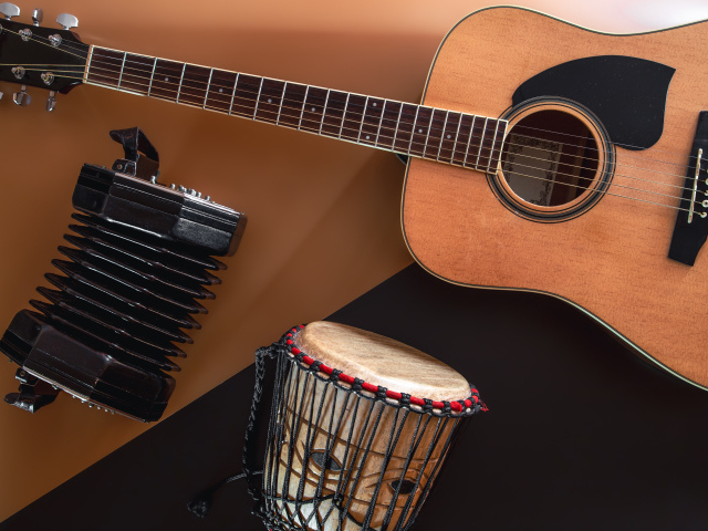 Гитара, гармошка и барабан на столе