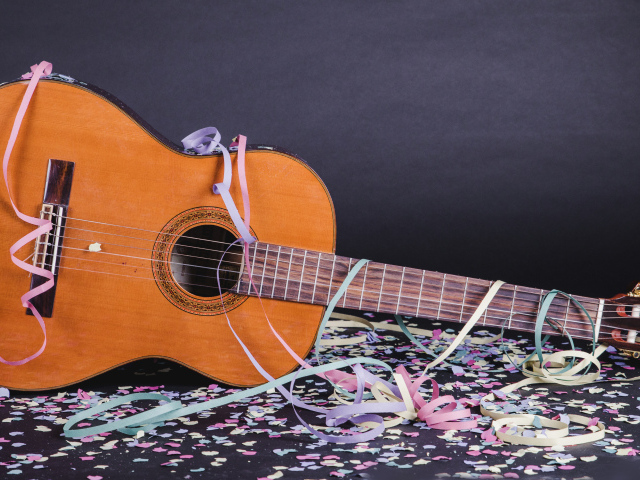 Гитара в конфетти у серой стены