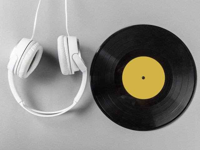 Виниловая пластинка и наушники на сером столе