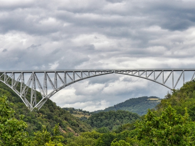 Вид на стальной виадук над покрытыми зеленью горами
