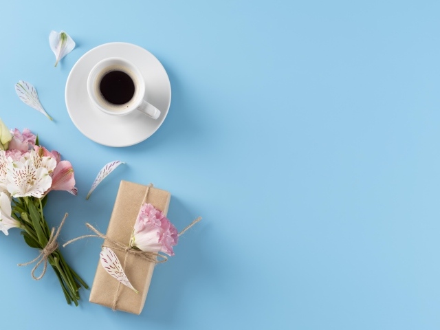 Букет цветов альстромерии с  подарком и чашкой кофе на голубом фоне