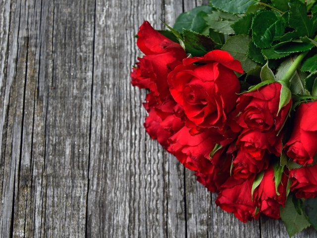 Букет красных роз на деревянном столе