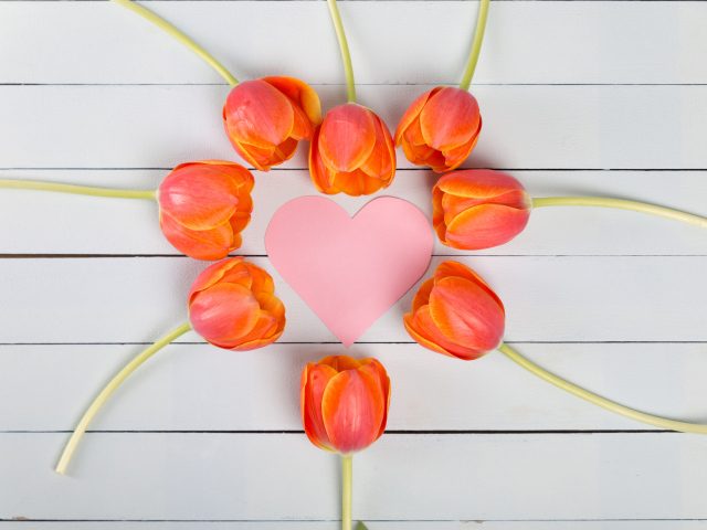 Оранжевые тюльпаны с розовым сердцем на сером столе