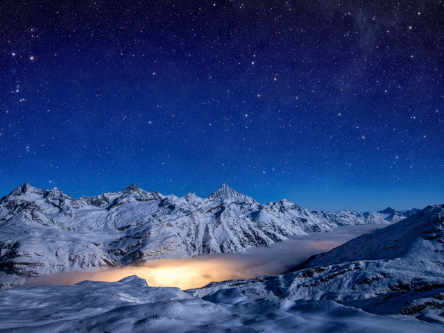 Красивое ночное небо над покрытыми снегом горами