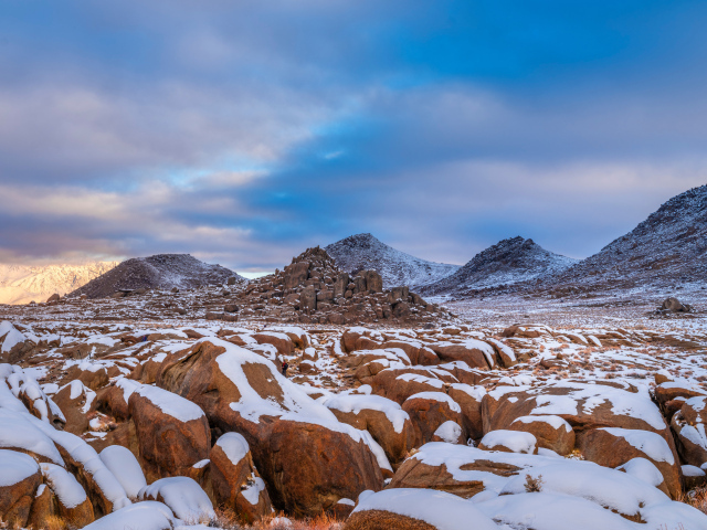 Большие заснеженные камни в горах 