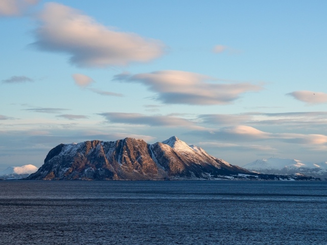 Скала в лучах солнца в море