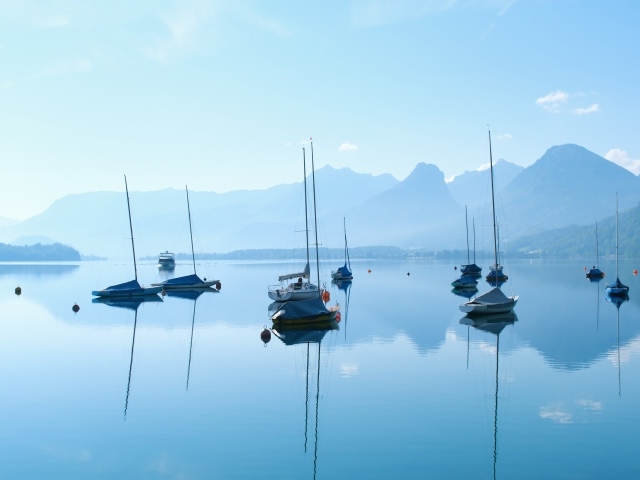 Лодки на озере у гор на рассвете в тумане