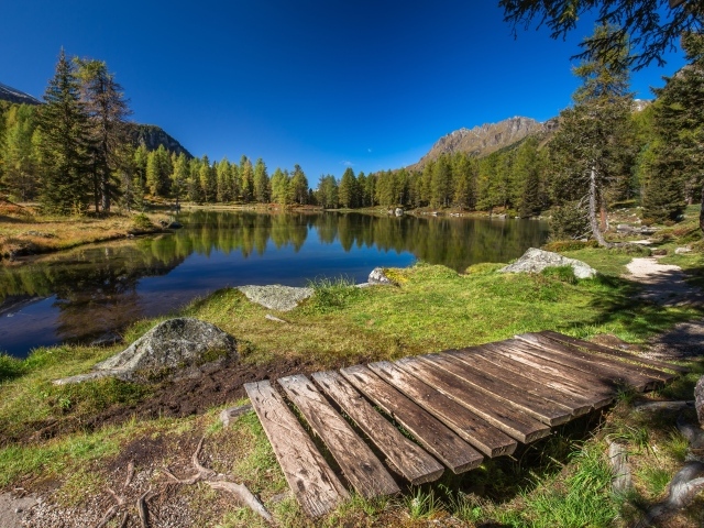 Мост на берегу озера в горах под голубым небом