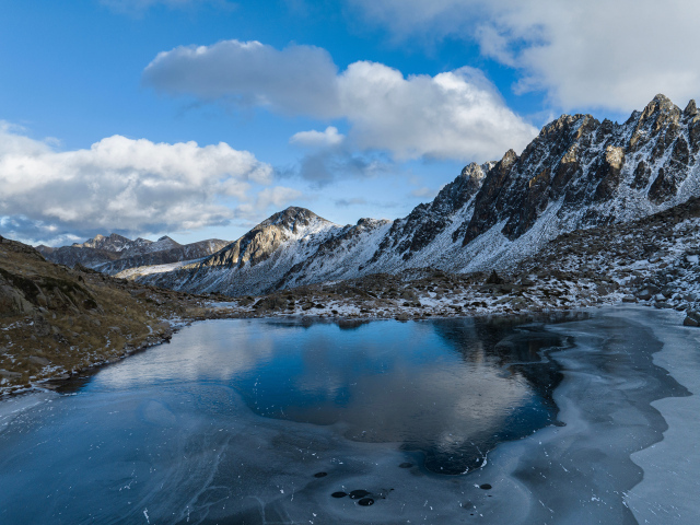 Холодный мороз покрывает льдом воду горного озера