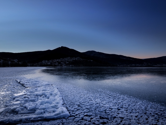 Заледеневшая вода в горном озере в сумерках