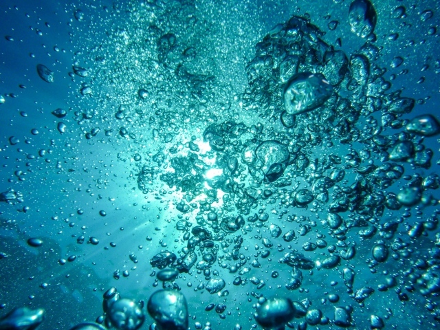 Пузыри в голубой воде в лучах солнца